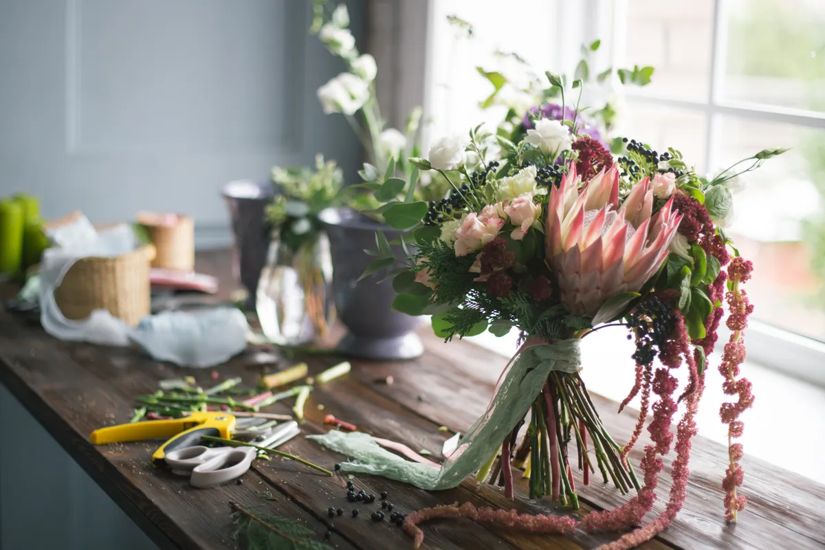 Protea bouquet on a florist's bench with tools
