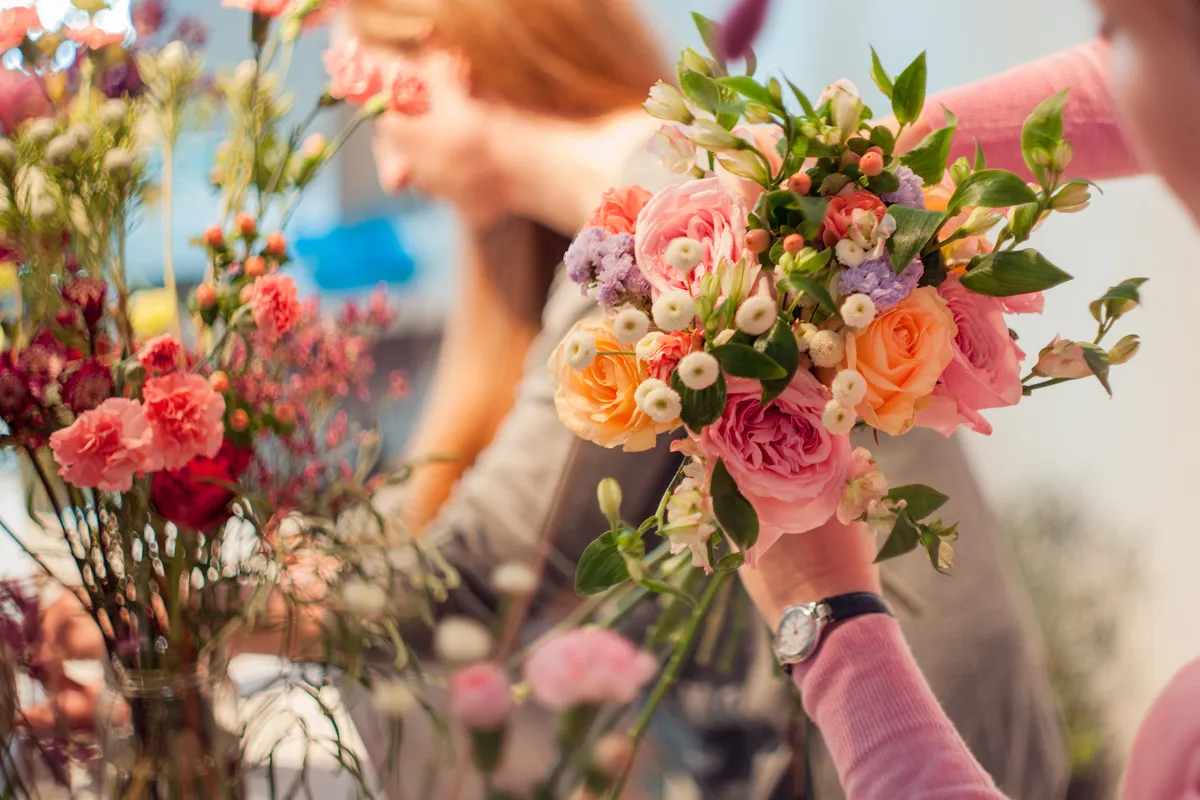 Florist's hands building a bright bouquet